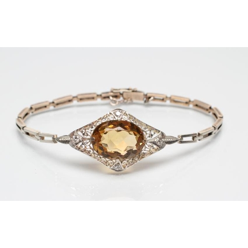 232 - AN EDWARDIAN BRACELET, the convex filigree lozenge panel claw set with an oval facet cut citrine wit... 