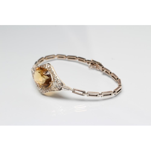 232 - AN EDWARDIAN BRACELET, the convex filigree lozenge panel claw set with an oval facet cut citrine wit... 