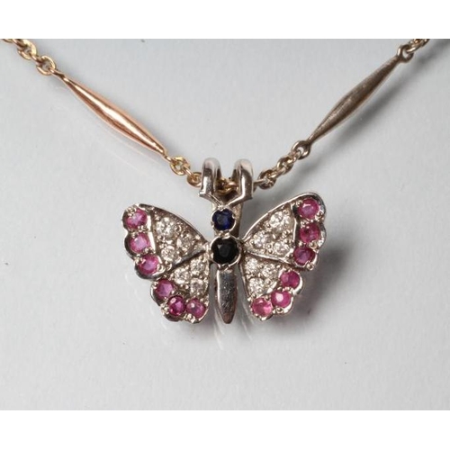 240 - A BUTTERFLY PENDANT with diamond and ruby set wings and sapphire body, stamped 375, on an unmarked t... 