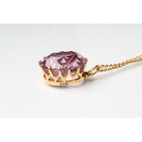 242 - AN AMETHYST PENDANT, the oval facet cut stone claw set to a plain frame, stamped 9ct, on unmarked ch... 