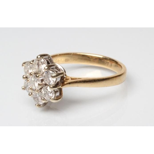 243 - A DIAMOND CLUSTER RING, the seven round brilliants claw set to a plain 18ct gold shank, Sheffield, s... 