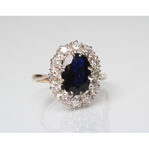 245 - A SAPPHIRE AND DIAMOND CLUSTER RING, the oval facet cut sapphire claw set to a border of twelve roun... 