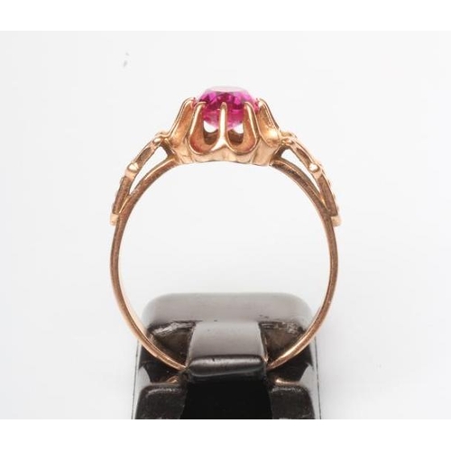 251 - A RUBY COCKTAIL RING, the oval facet cut stone claw set to a frilled mount and cast shoulders to a p... 