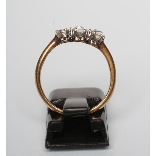 252 - A THREE STONE DIAMOND RING, the three old brilliant cut stones claw set to a plain shank stamped 18c... 