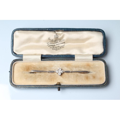 254 - AN EDWARDIAN DIAMOND BROOCH, the propellor bars centred by four open back collet set old and brillia... 