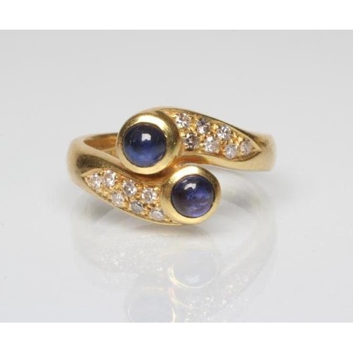 258 - A SAPPHIRE AND DIAMOND DRESS RING, the two circular cabochon polished sapphires open back collet set... 