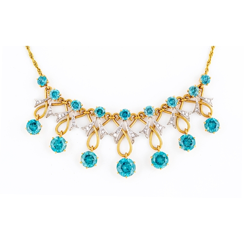 260 - A TOPAZ AND DIAMOND NECKLACE, with nine round facet cut stones claw set in 18ct gold to fancy scroll... 