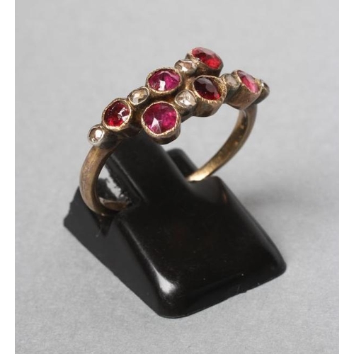 230 - A VICTORIAN RUBY AND DIAMOND CROSSOVER RING collet set with six rubies and five rose cut diamonds to... 