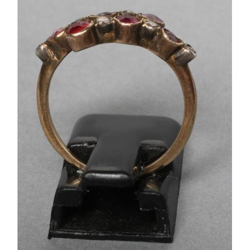 230 - A VICTORIAN RUBY AND DIAMOND CROSSOVER RING collet set with six rubies and five rose cut diamonds to... 