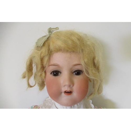 73 - An Armand Marseille bisque socket head doll, with brown glass sleeping eyes, open mouth, teeth, blon... 