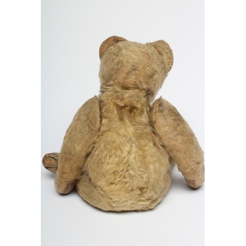 151 - An early German teddy, straw filled, with light orange plush, later sewn nose, button eyes, leather ... 