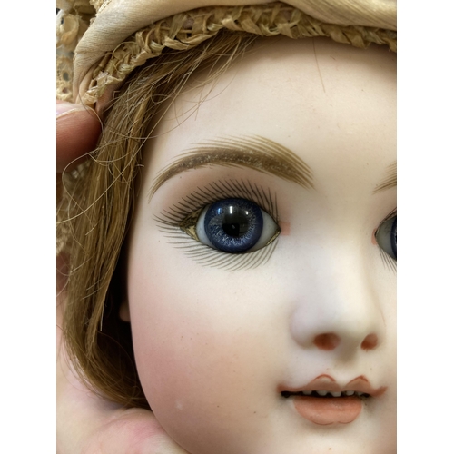 11 - A  French Eden Bebe bisque socket head doll, with blue glass paperweight eyes, open mouth, six top t... 