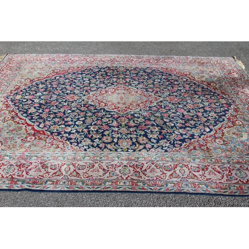 A PERSIAN CARPET, the puce field with repeating flower pattern in