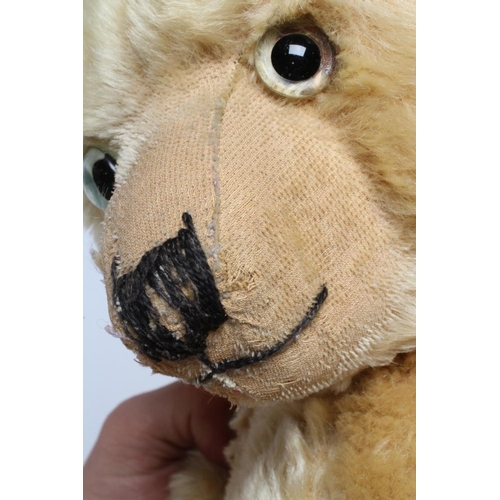 118 - An English teddy bear, possibly Farnell, with clear glass eyes, sewn nose, shaved snout, orange plus... 