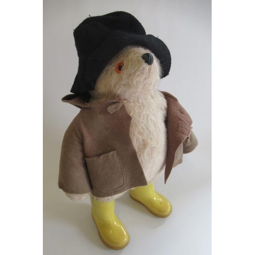 145 - A Paddington bear, with brown coat, black hat and yellow dunlop boots, together with a Puffin editio... 