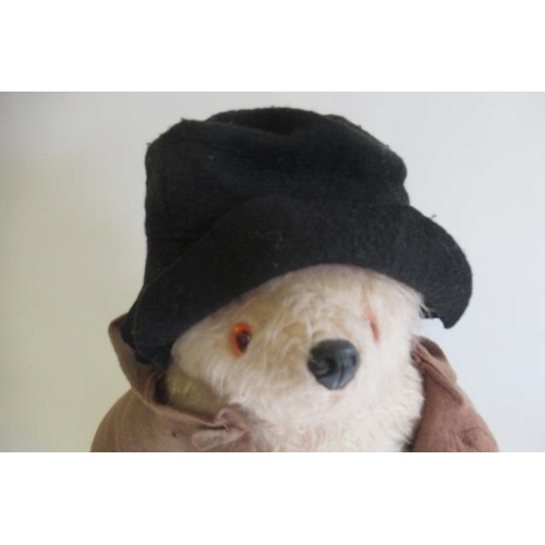 145 - A Paddington bear, with brown coat, black hat and yellow dunlop boots, together with a Puffin editio... 