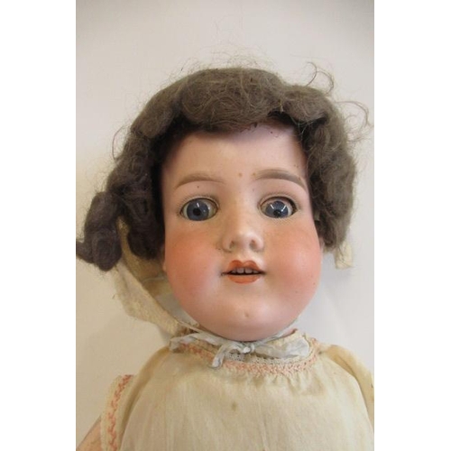 35 - An Armand Marseille bisque socket head doll, with blue glass eyes, open mouth, teeth, brown wig, woo... 