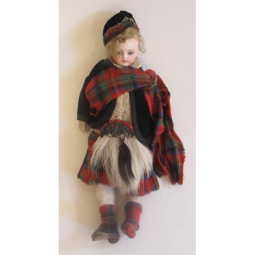 32 - A bisque socket head Scottish boy doll, with blue glass fixed eyes, closed mouth, fabric body with b... 