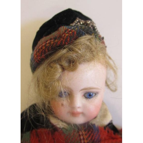 32 - A bisque socket head Scottish boy doll, with blue glass fixed eyes, closed mouth, fabric body with b... 