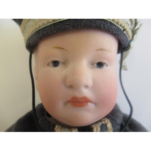 36 - A Heubach bisque head solemn boy, with moulded and painted features, closed mouth, bent limb composi... 