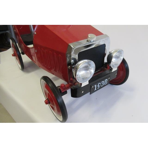 288 - A pedal car, of metal and plastic construction, painted in red, with two tone wheels and faux intern... 