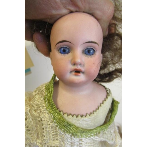 53 - An Armand Marseille bisque shoulder head doll, with blue glass fixed eyes, open mouth, brown wig, ki... 