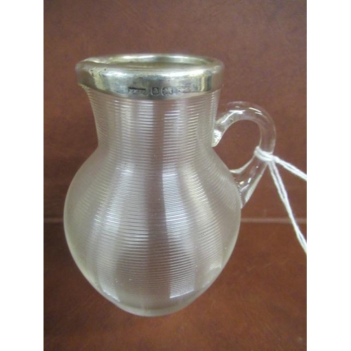 242 - SILVER RIMMED GLASS JUG