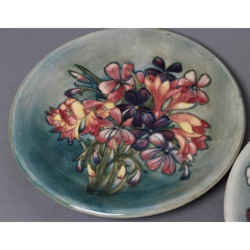 32 - TWO MOORCROFT POTTERY PLATES, mid 20th century, both of plain circular form, tubelined and painted i... 