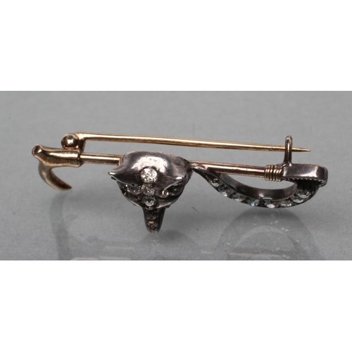 376 - AN EDWARDIAN STOCK PIN, the crop centred by a fox mask with ruby cabochon eyes and diamond set head ... 