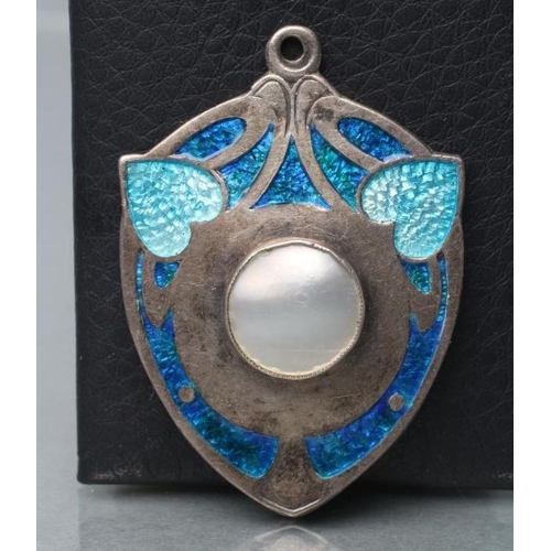 378 - AN EDWARDIAN SILVER AND ENAMEL SECESSIONIST PENDANT, maker James Fenton, Birmingham 1909, the shield... 