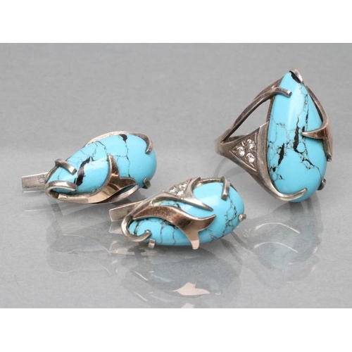 382 - A TURQUOISE MATRIX RING, the tear polished stone asymmetrically set in unmarked white metal with thr... 