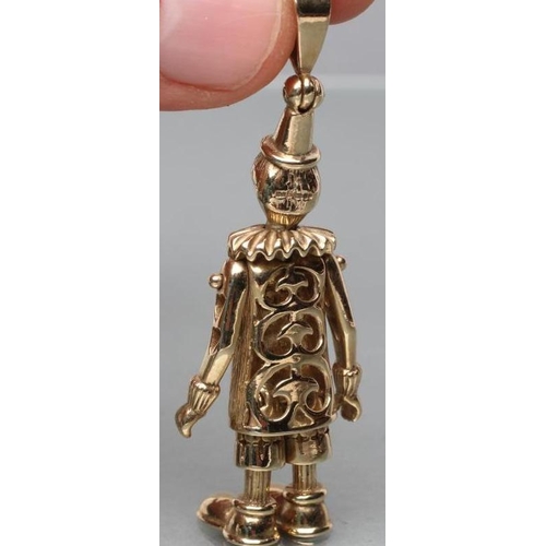 384 - A 9CT GOLD ARTICULATED CLOWN PENDANT with ruby eyes, his tunic set with pairs of sapphires, emeralds... 