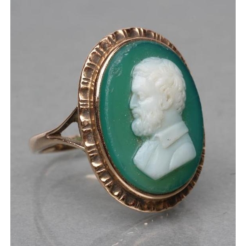 387 - A GREEN AND WHITE GLASS CAMEO RING, the oval panel cut with the head and shoulders portrait of a bea... 