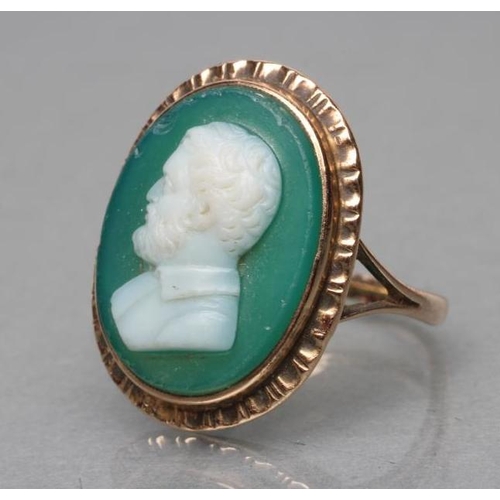 387 - A GREEN AND WHITE GLASS CAMEO RING, the oval panel cut with the head and shoulders portrait of a bea... 