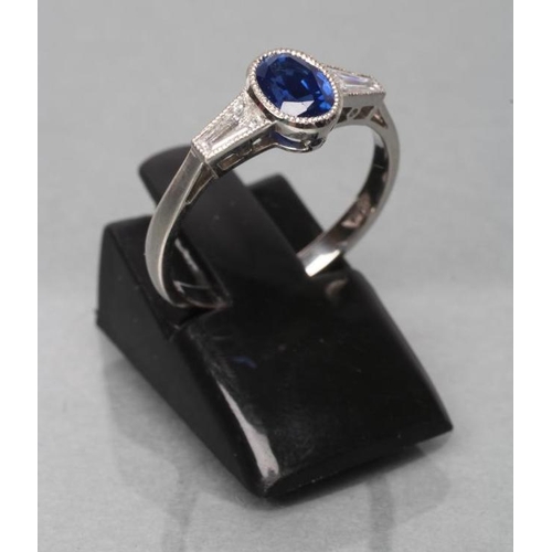 395 - A CEYLON SAPPHIRE AND DIAMOND RING, the oval facet cut sapphire of 1.26cts collet set to angular sho... 