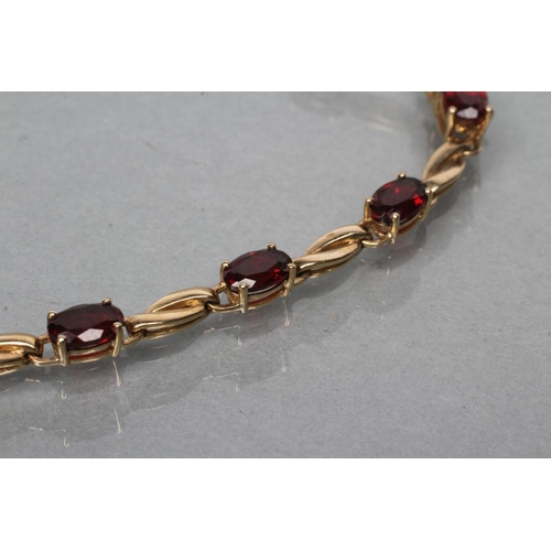 397 - A GARNET BRACELET, the twelve oval facet cut stones claw set to a plain chain, stamped 375 (Est. plu... 