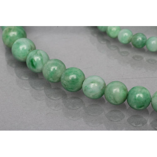 398 - A STRING OF POLISHED GRADUATING JADE BEADS, 19