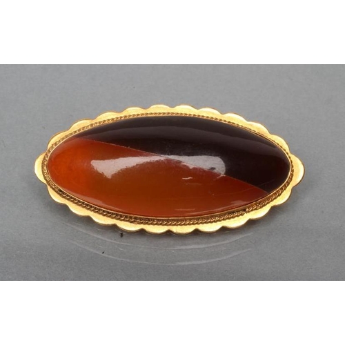 400 - AN AMBER BROOCH, the eliptical bi-colour panel open back set to an engraved mount, stamped RK9, 5cm ... 