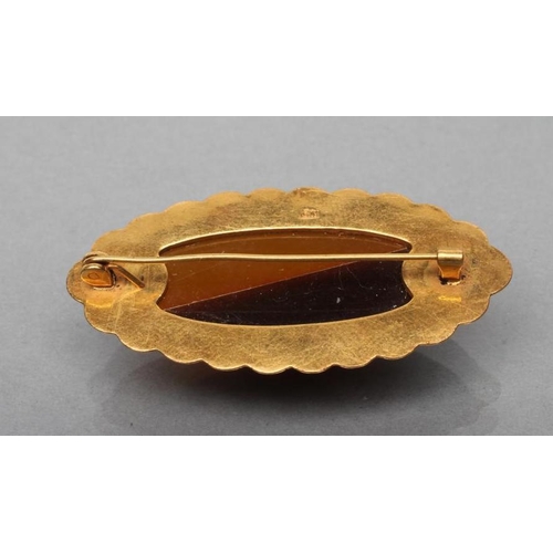 400 - AN AMBER BROOCH, the eliptical bi-colour panel open back set to an engraved mount, stamped RK9, 5cm ... 