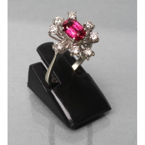 411 - A RUBY AND DIAMOND DRESS RING, the oval facet cut ruby claw set to a star border of eight small old ... 