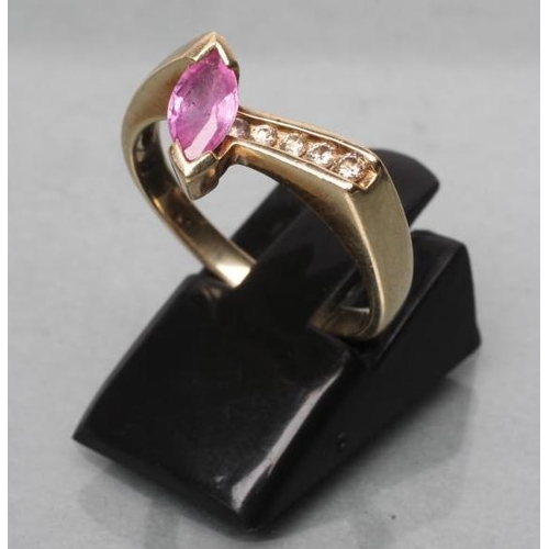 423 - A PINK SAPPHIRE AND DIAMOND ANGULAR CROSSOVER RING, the marquise cut sapphire beside four graduated ... 