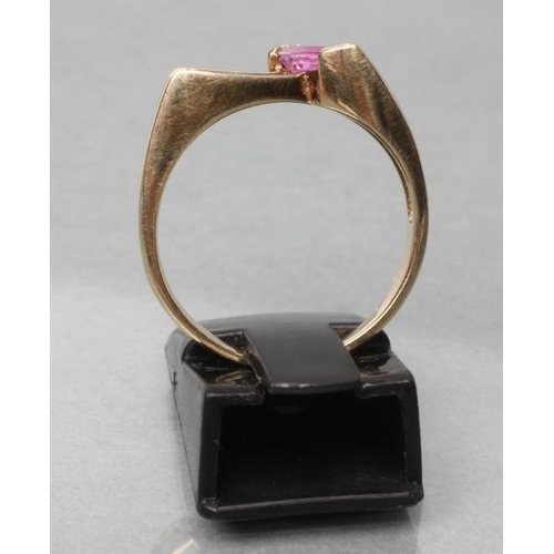 423 - A PINK SAPPHIRE AND DIAMOND ANGULAR CROSSOVER RING, the marquise cut sapphire beside four graduated ... 