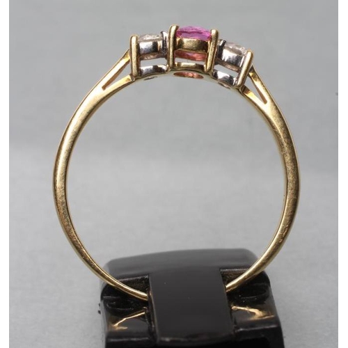 429 - A PINK SAPPHIRE AND DIAMOND THREE STONE RING, the oval facet cut sapphire claw set and flanked by tw... 