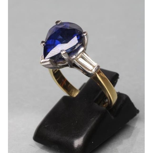 444 - A SAPPHIRE DRESS RING, the pear cut stone claw set to shoulders each set with a shaped baguette cut ... 