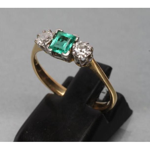 460 - AN EMERALD AND DIAMOND THREE STONE RING, centred by a square cut emerald claw set and flanked by two... 