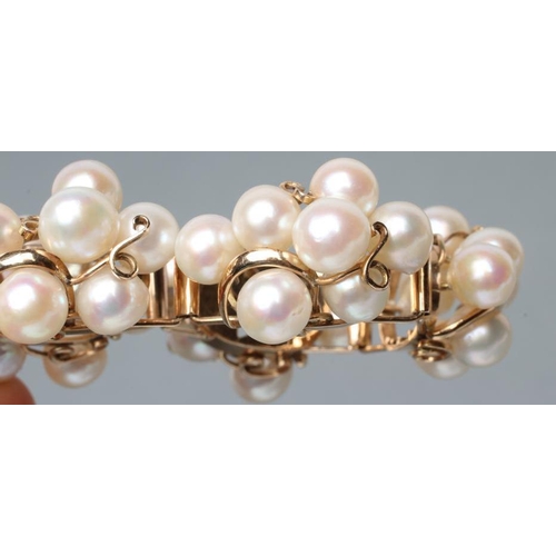 464 - A MODERN CULTURED PEARL BRACELET, the seven abstract set panels of seven pearls wired to a plain fra... 