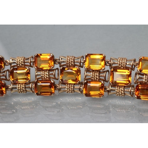 473 - A 9CT GOLD AND CITRINE BRACELET, the twenty four step cut citrines claw set to bow shaped links, wit... 