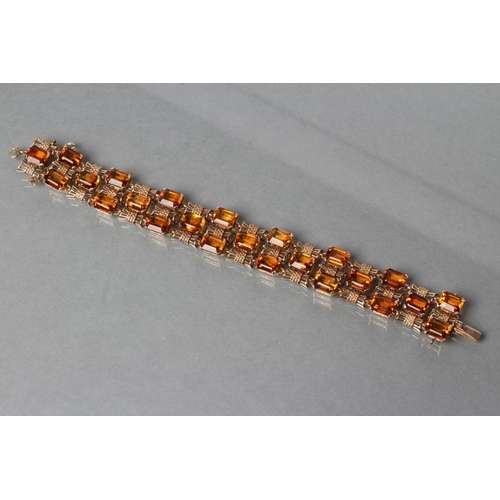 473 - A 9CT GOLD AND CITRINE BRACELET, the twenty four step cut citrines claw set to bow shaped links, wit... 