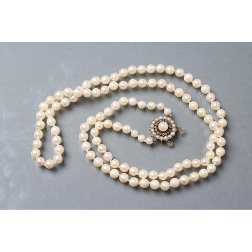 481 - A SINGLE STRING OF CULTURED PEARLS, with split pearl and emerald chip 9ct gold flower clasp, London ... 