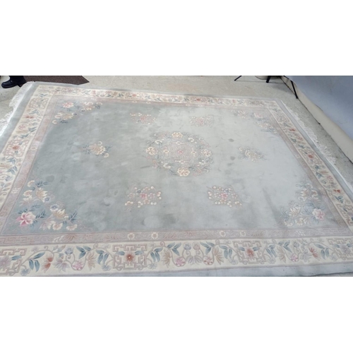 493 - A CHINESE WASHED AND FRINGED CARPET, the pale green field with central circular floral gul in rose p... 